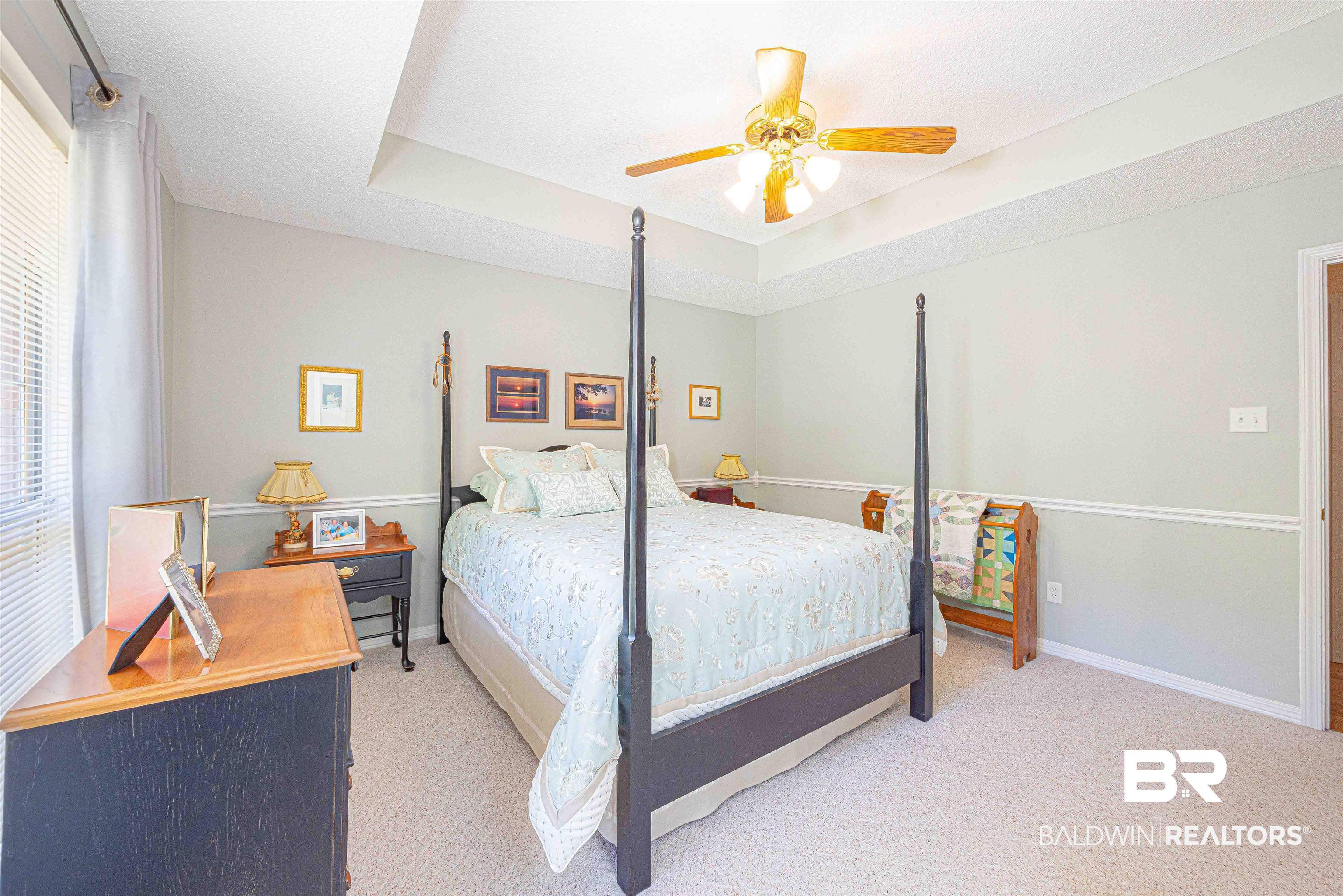 485 Ridgewood Drive Daphne, AL 36526 - Photo 25 of 38 Bedroom with a tray ceiling, baseboards, a ceiling fan, and light colored carpet
