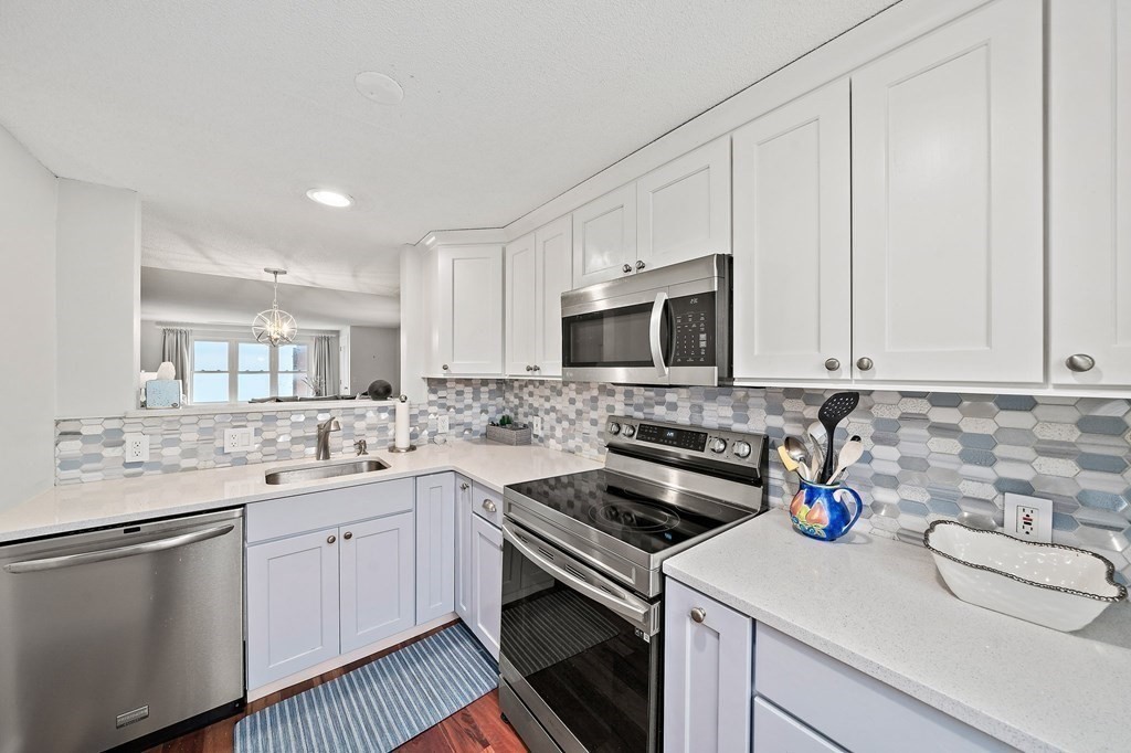 20 Rockland House Road, Unit 406 Hull, MA 02045 - Photo 12 of 39 a kitchen with a sink stove and cabinets
