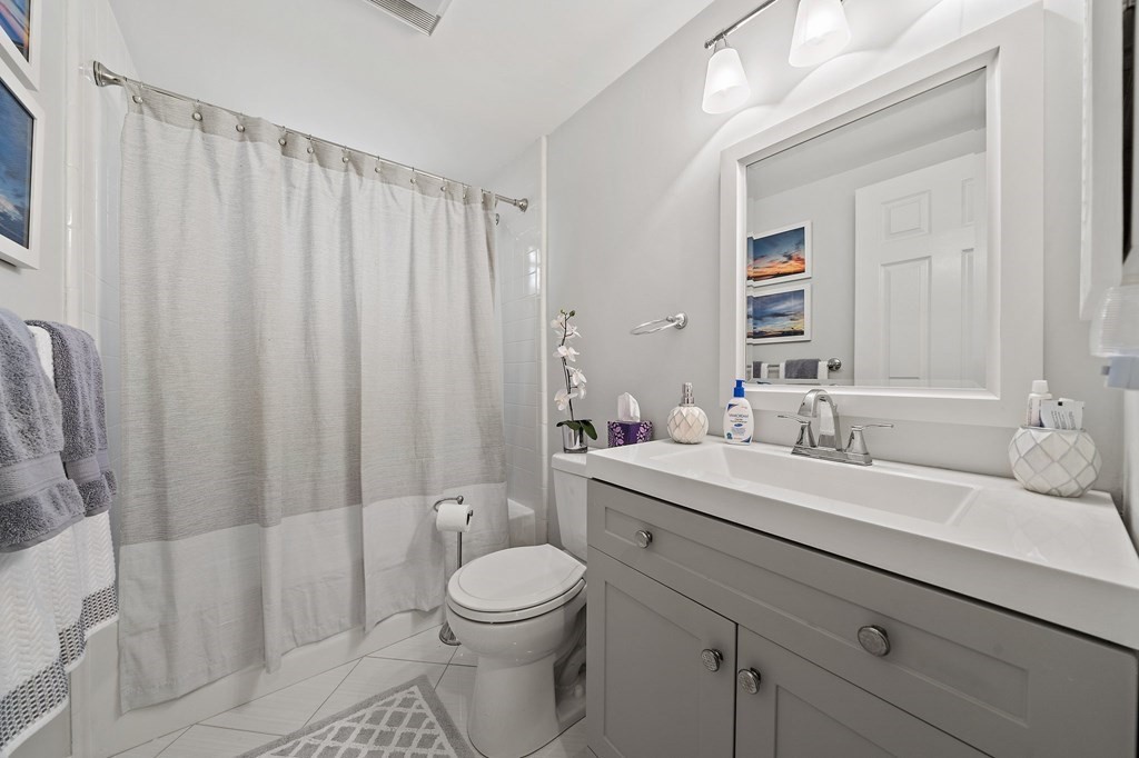 20 Rockland House Road, Unit 406 Hull, MA 02045 - Photo 20 of 39 a bathroom with a toilet a sink a tub and mirror