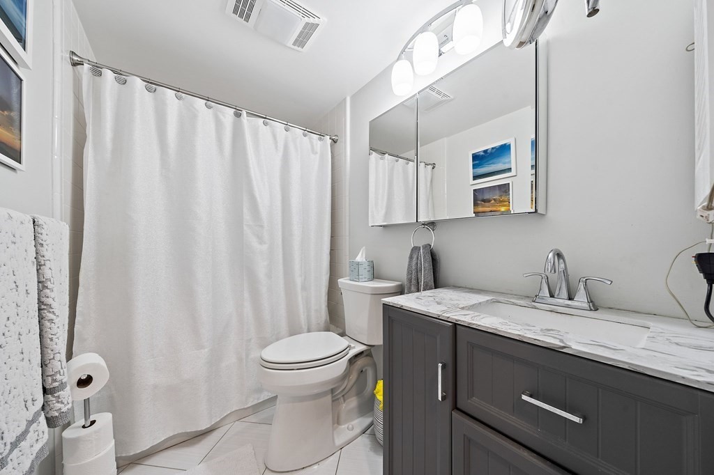 20 Rockland House Road, Unit 406 Hull, MA 02045 - Photo 26 of 39 a bathroom with a granite countertop sink toilet and a mirror