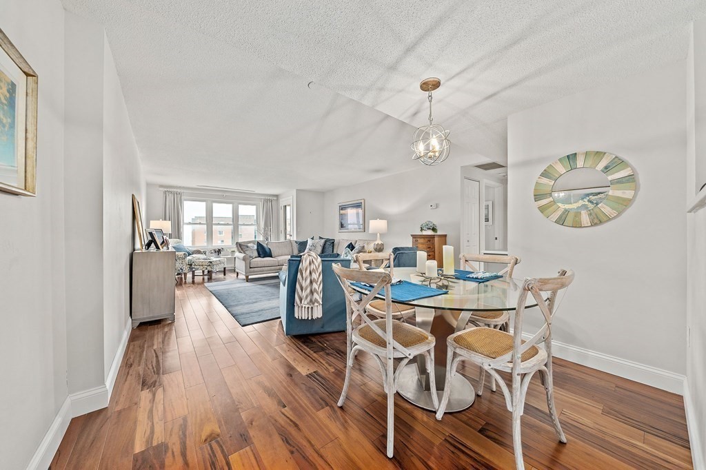 20 Rockland House Road, Unit 406 Hull, MA 02045 - Photo 8 of 39 a view of a dining room with furniture a chandelier and wooden floor