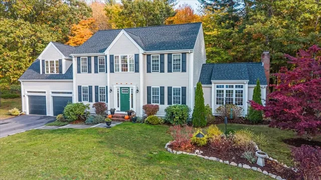 a front view of a house with a yard and potted plants