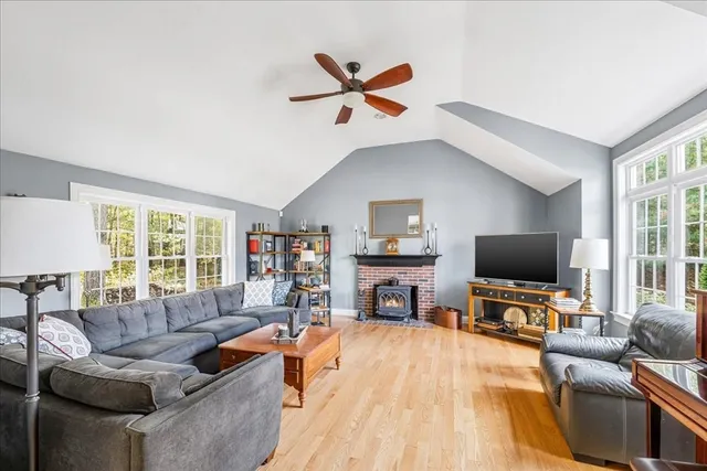 a living room with furniture flat screen tv and a large window