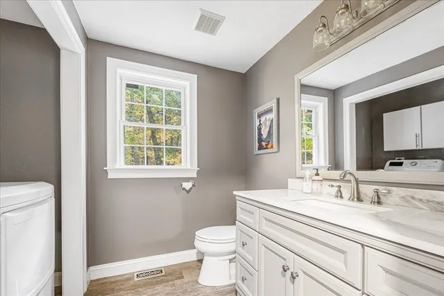 a bathroom with a sink a toilet and a window