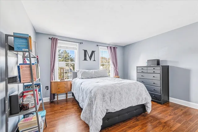 a bedroom with a bed a couch and a flat tv screen on the dresser