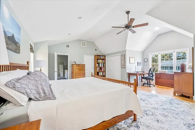 a spacious bedroom with a bed a large window and chair