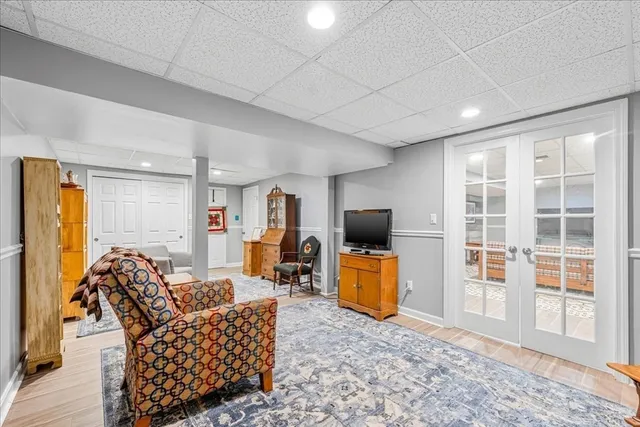 a living room with furniture a flat screen tv and a refrigerator