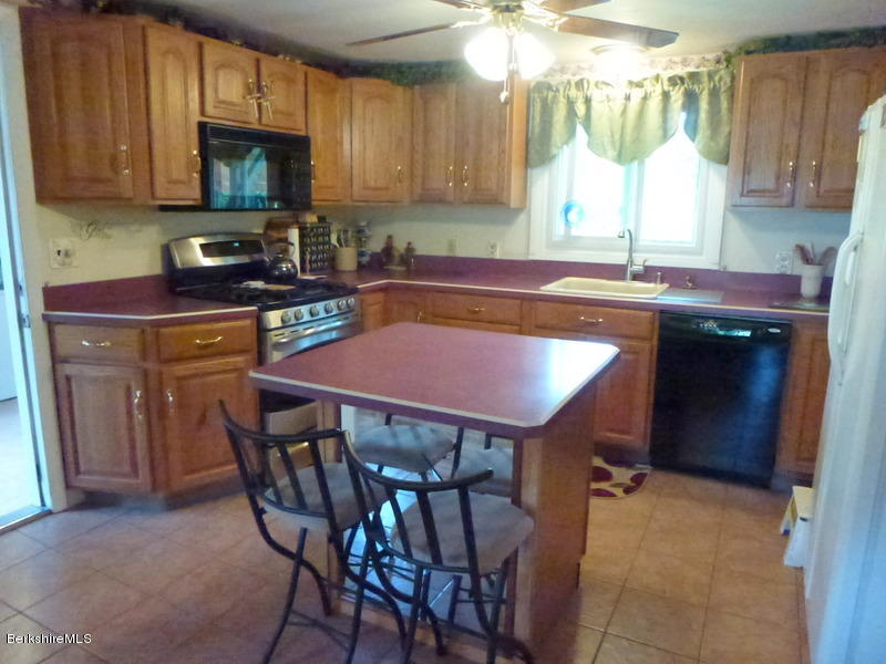 148 Mohawk Trail Florida, MA 01247 - Photo 8 of 18 a kitchen with a table chairs sink and cabinets
