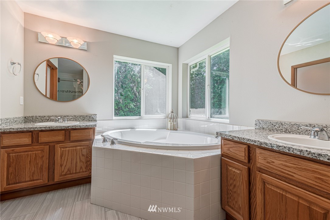 16108 OK Mill Road Snohomish, WA 98290 - Photo 12 of 23 a bathroom with a granite countertop sink a mirror and a window