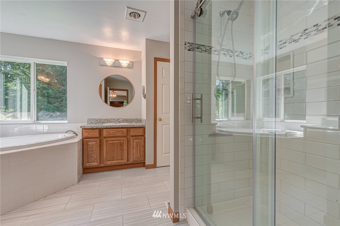 16108 OK Mill Road Snohomish, WA 98290 - Photo 13 of 23 a bathroom with a double vanity sink a mirror a bathtub and shower