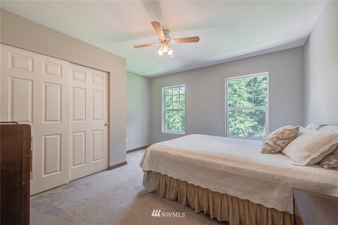 16108 OK Mill Road Snohomish, WA 98290 - Photo 14 of 23 a bedroom with a large bed and a ceiling fan