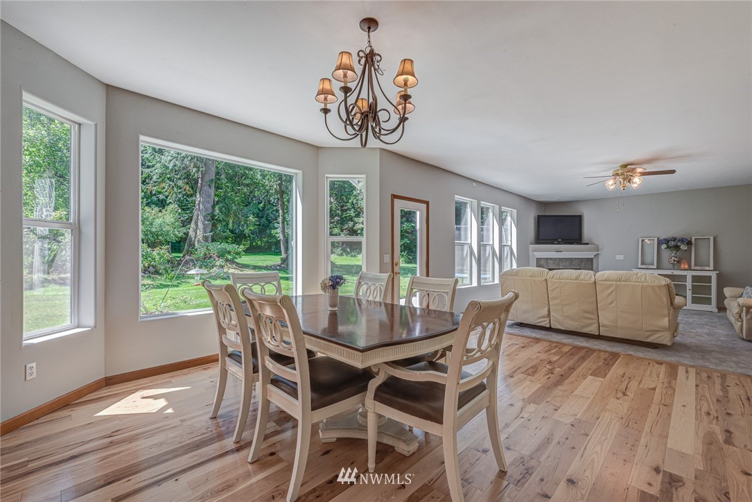 16108 OK Mill Road Snohomish, WA 98290 - Photo 9 of 23 a view of a dining room with furniture large windows and wooden floor