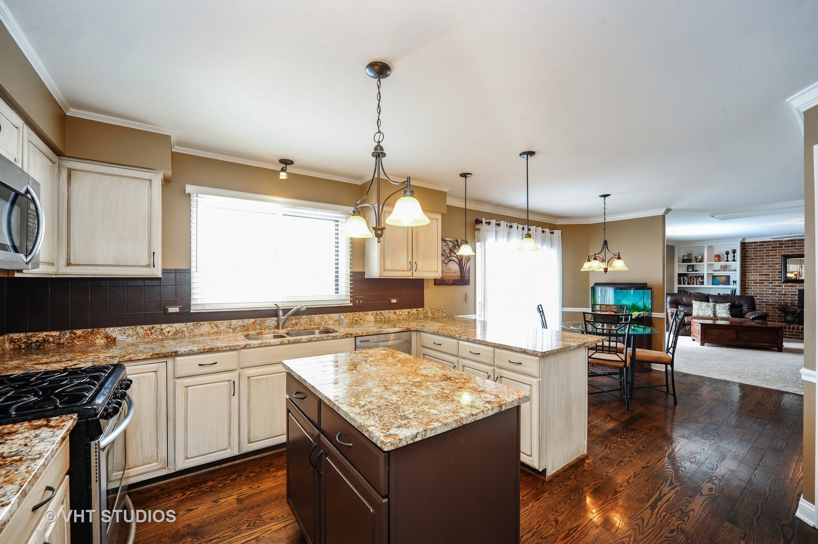 630 Raintree Road Buffalo Grove, IL 60089 - Photo 4 of 26 a kitchen with a stove a sink a oven a dining table and chairs with wooden floor