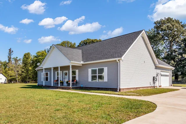 a front view of a house with yard and swimming pool