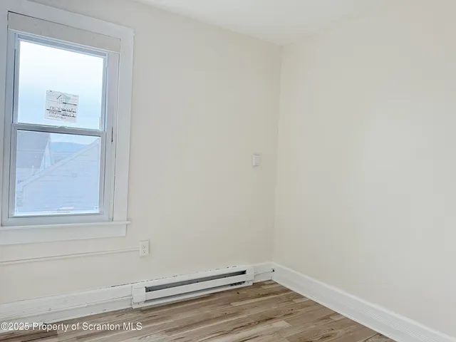 a view of a small space with wooden floor and a window