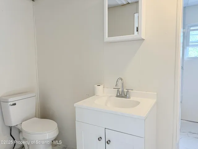 a bathroom with a sink toilet and a mirror