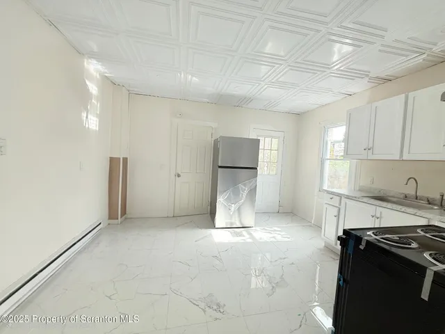 a kitchen with a refrigerator and a stove top oven