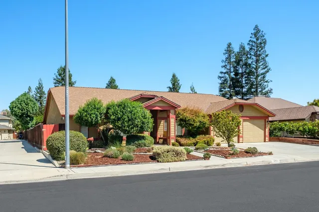 a view of a patio with a table and chairs under an umbrella next to a road