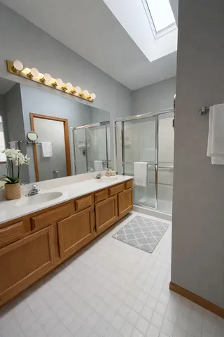 a spacious bathroom with a double vanity sink and a mirror