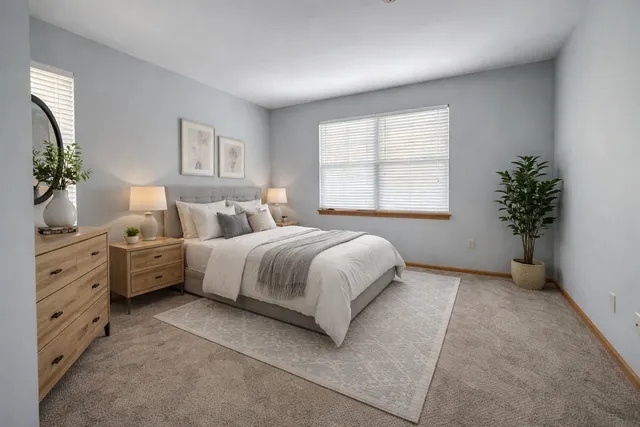 a spacious bedroom with a large bed and a potted plant