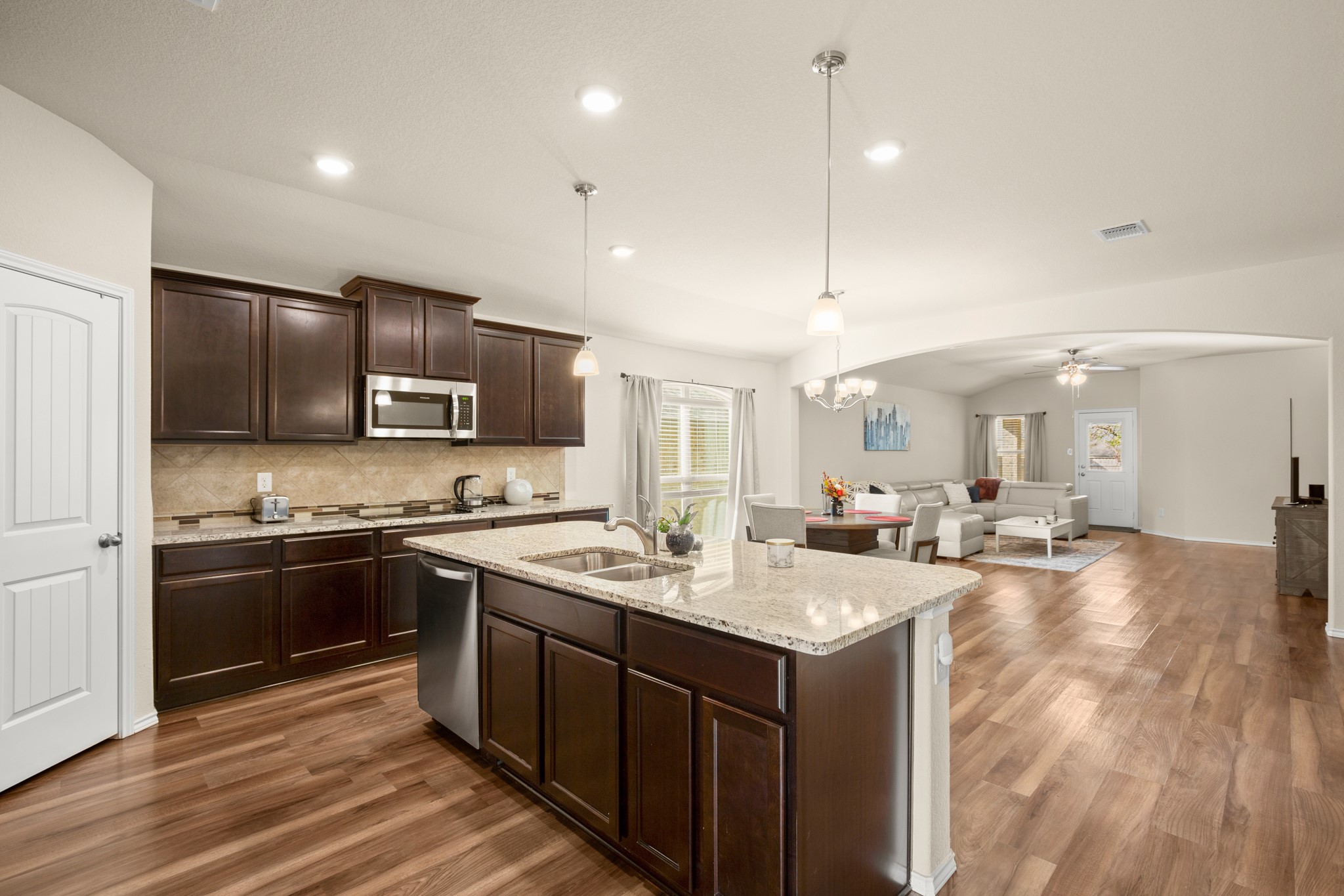 5526 Perdita Drive Belton, TX 76513 - Photo 26 of 26 Kitchen with dark wood finish cabinetry, light stone countertops, open floor plan, ceiling fan, and dark wood-style flooring