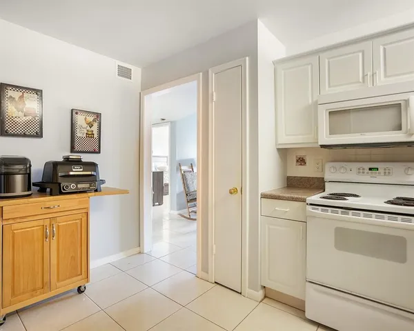 a kitchen with white cabinets and white appliances