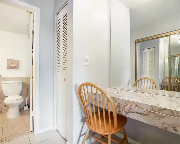 a view of a hallway with wooden floor and a bathroom view