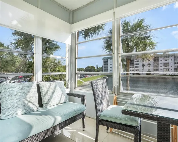 a living room with furniture and a floor to ceiling window