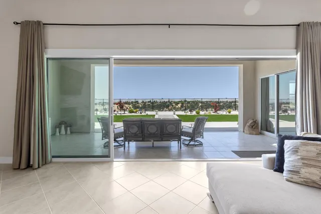 a bedroom with a bed lamp and a large window