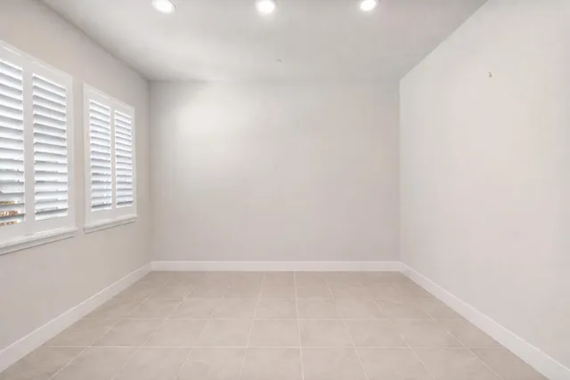 a spacious en suite bathroom with a tub double sink window and mirror