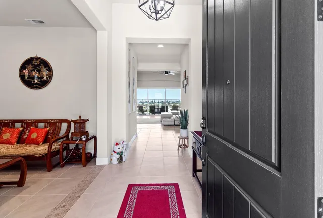 a large kitchen with a counter space a sink appliances and living room view
