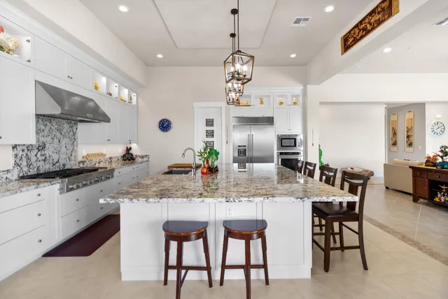a living room with furniture floor to ceiling window and a potted plant