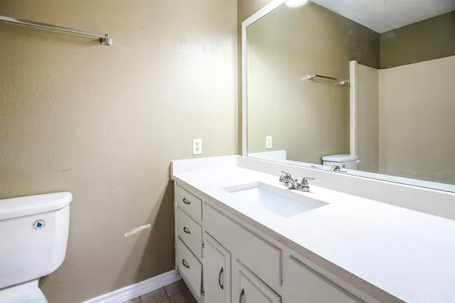 a bathroom with a sink a toilet and a mirror