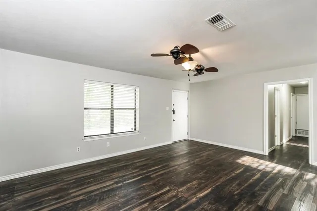 a view of a room with a window and wooden floor