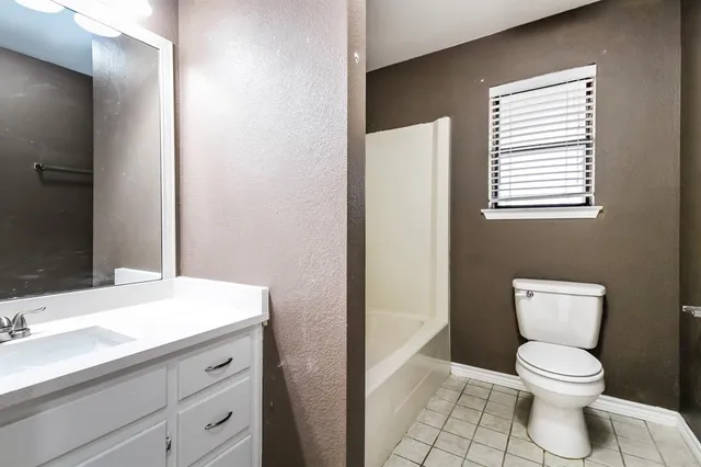 a bathroom with a toilet a sink and a mirror