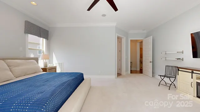 a spacious bedroom with a bed a couch and a chandelier