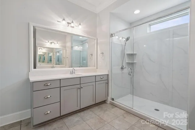 a bathroom with a shower sink and mirror
