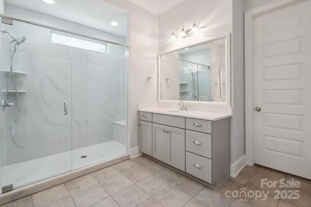 a bathroom with a shower sink and mirror