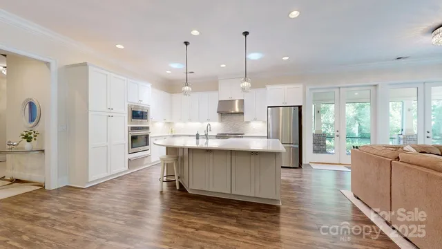a large kitchen with cabinets wooden floor and stainless steel appliances