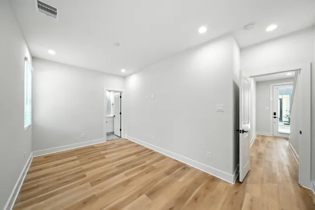 a view of empty room with wooden floor