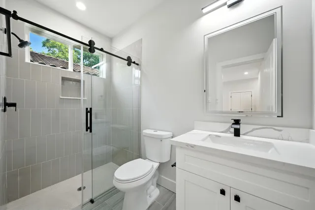 a bathroom with a sink a toilet and shower