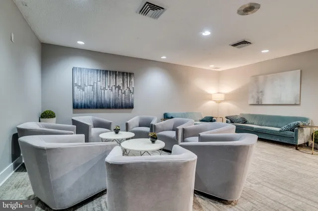 a living room with couches and kitchen with stainless steel appliances