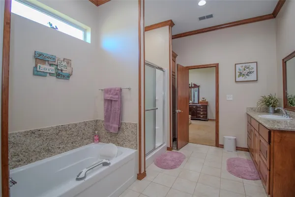 a bathroom with a granite countertop tub sink and mirror