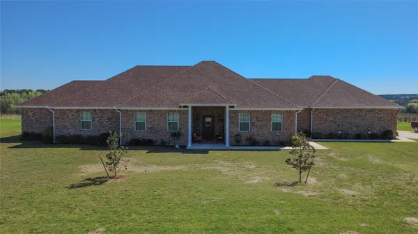 a view of a house with a yard and sitting area