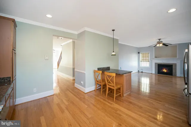 a kitchen with granite countertop wooden floors white cabinets and stainless steel appliances