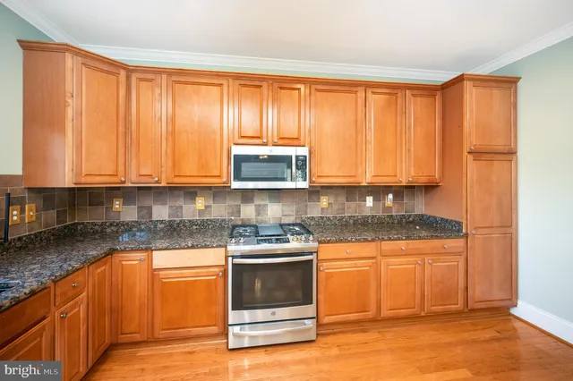a kitchen with granite countertop a stove a sink and a granite counter tops