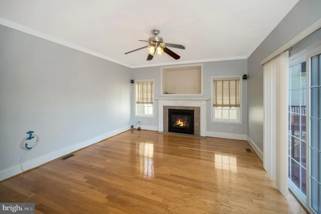 a view of a room with wooden floor and a ceiling fan