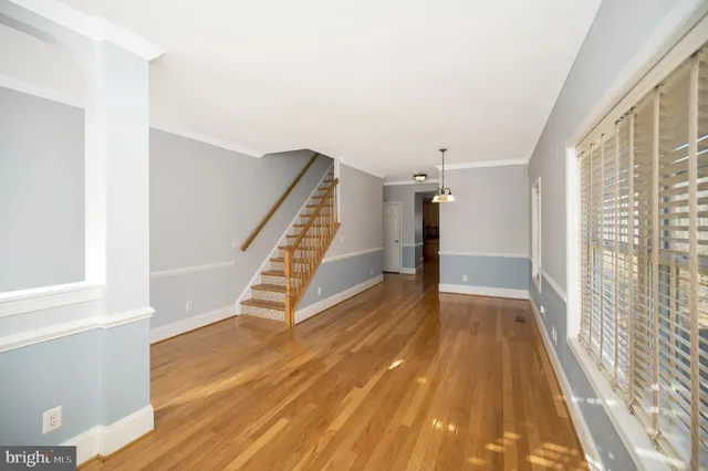 a view of a room with wooden floor fridge and windows