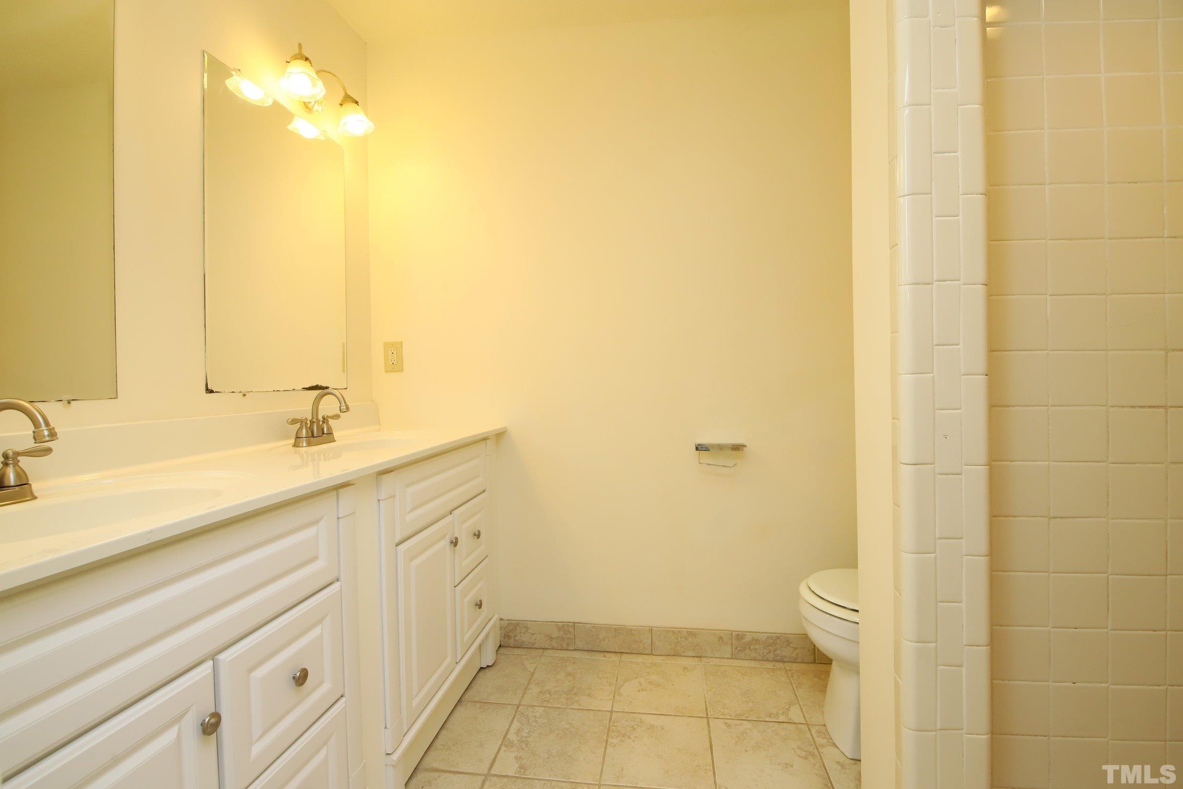 4224 Bluewing Road Raleigh, NC 27616 - Photo 19 of 29 a spacious bathroom with a granite countertop sink and a mirror