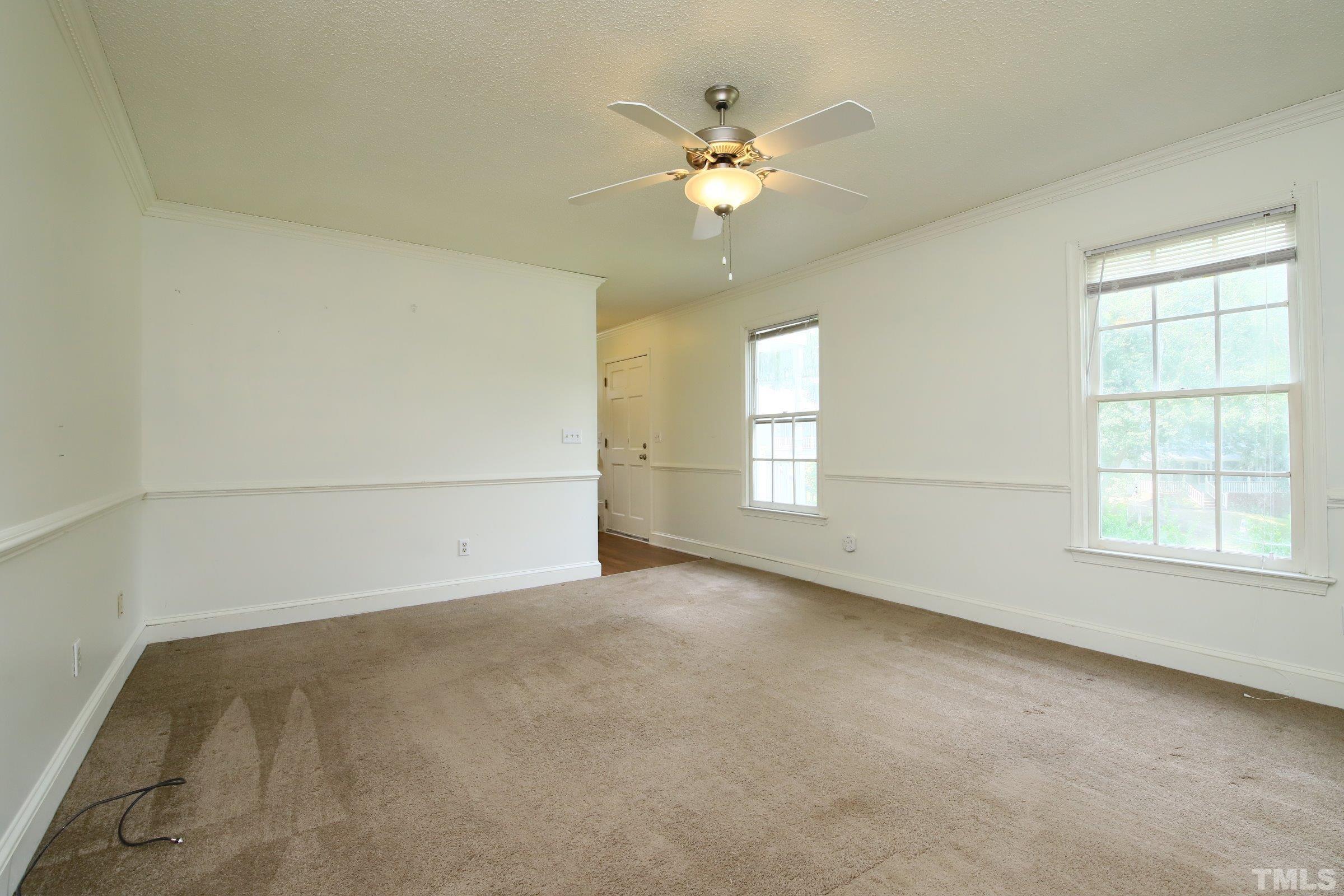 4224 Bluewing Road Raleigh, NC 27616 - Photo 7 of 29 en empty room with windows and chandelier fan